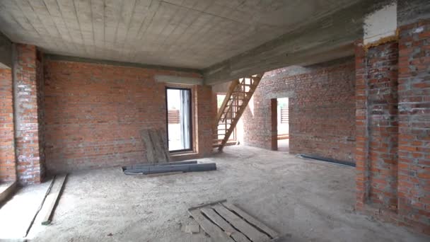 Interiör i den oavslutade byggnaden av rummet. Konstruktion av tegel och inre skiljeväggar mellan rummen — Stockvideo