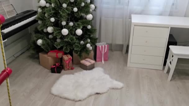 Stijlvol interieur met kerstboom en geschenkdozen. kerstboom in de slaapkamer — Stockvideo