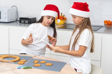 Çocuklar mutfakta Noel kurabiyeleri süslüyor. Yüksek kalite fotoğraf