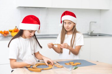 Çocuklar mutfakta Noel kurabiyeleri süslüyor. Yüksek kalite fotoğraf