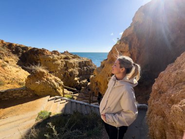 Carvoeiro gün batımında kayalıklar boyunca yürür. Carvoeiro, Portekiz. 30 Kasım 2025. Yüksek kalite fotoğraf