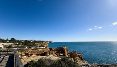 Carvoeiro gün batımında kayalıklar boyunca yürür. Carvoeiro, Portekiz. 30 Kasım 2025. Yüksek kalite fotoğraf