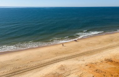  Atlantik 'teki kumlu sahil. Kum taşı kayalıkları olan bir sahilin gün batımında manzara. Albufeira, Algarve, Portekiz yakınlarındaki Praia 'nın sarı sahilinde gelgit var. Yüksek kalite fotoğraf