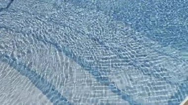Cilt korkutma ürünleri, spa ve meditasyon için serin bir arka plan olarak ışık yansıtmalı soyut mavi su renk dalgaları. Yüzeyinde dalgalanmalar olan su. Temiz su dalgalı dokusu. Arka planlar. Yüksek kalite fotoğraf