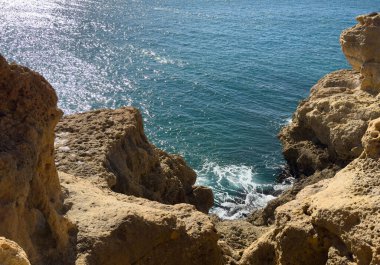 Okyanus dalgaları kayalık kıyıya doğru yuvarlanıyor. Güzel deniz manzarası. Yuvarlanan dalgalarla güzel okyanus kayalık kıyılarının havadan görünüşü. İnsansız hava aracı okyanus dalgaları üzerinde kayalık kıyıya doğru süzülüyor. Yüksek kalite fotoğraf
