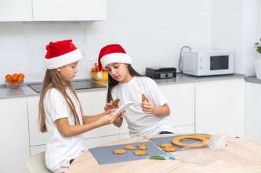 Çocuklar Noel kurabiyelerini masaya dekore ettiler. Yüksek kalite fotoğraf