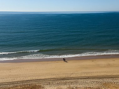  Atlantik 'teki kumlu sahil. Kum taşı kayalıkları olan bir sahilin gün batımında manzara. Albufeira, Algarve, Portekiz yakınlarındaki Praia 'nın sarı sahilinde gelgit var. Yüksek kalite fotoğraf
