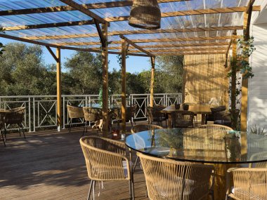 Cam sürgülü kapıları olan modern bir yaşam alanına bağlı şık bir açık hava oturma alanı. Yüksek kalite fotoğraf