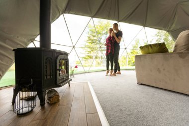 a couple in geo dome tents. Cozy, camping, glamping, holiday, vacation lifestyle concept. Outdoors cabin, scenic background
