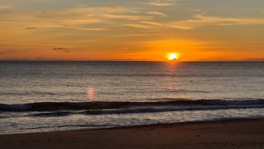 Sahil gün batımı, ufukta güneş boş kumsalda hiç insan yok, renkli gökyüzü. Yüksek kalite fotoğraf