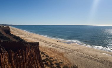  Atlantik 'teki kumlu sahil. Kum taşı kayalıkları olan bir sahilin gün batımında manzara. Albufeira, Algarve, Portekiz yakınlarındaki Praia 'nın sarı sahilinde gelgit var. Yüksek kalite fotoğraf