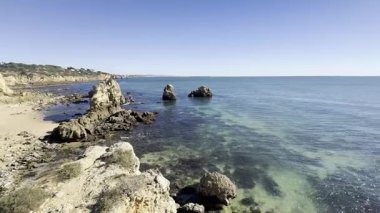 Sahilde muhteşem bir yaz manzarası. İpeksi kahverengi kumlarda büyük kayalar. Mavi okyanus suyuyla çevrili ve Leadbetter Sahili 'nde gün batımında güçlü bulutlarla kumsala yuvarlanan dalgalar. Yüksek kalite fotoğraf