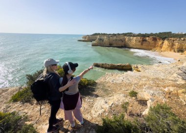 Uçurumun kenarındaki kadın yürüyüşçüler. Yaşam tarzı. Yürüyüş. Anne ve kızı güzel Algarve Praia da Morena 'da yürüyor. Yüksek kalite fotoğraf