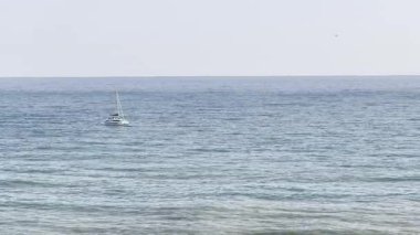 Beyaz yelkenli gün batımında hava manzarasında dalgaların üzerinde yüzüyor. Yüksek kalite 4k görüntü