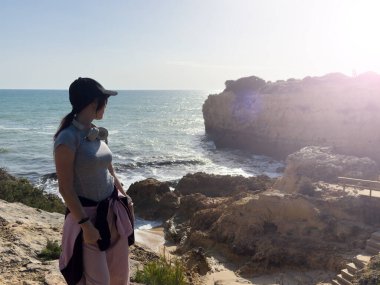 Kız okyanusun kenarında dinleniyor, denize bakıyor. Yüksek kalite fotoğraf