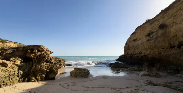 Güneşli ve açık bir bahar sabahında, gün doğumundan hemen sonra, Arnavutdeira sahilinin kayalıkları. Albandeira, Portekiz. Yüksek kalite fotoğraf