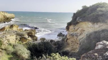 Güneşli ve açık bir bahar sabahında, gün doğumundan hemen sonra, Arnavutdeira sahilinin kayalıkları. Albandeira, Portekiz. Yüksek kalite fotoğraf