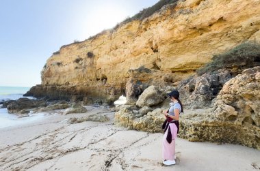 Kız okyanusun kenarında dinleniyor, denize bakıyor. Yüksek kalite fotoğraf