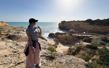 Kız okyanusun kenarında dinleniyor, denize bakıyor. Yüksek kalite fotoğraf