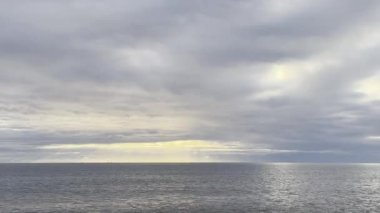 Gün doğumunda sakin kumlu bir plajda hafif dalgalar, yakın görüş. Yüksek kalite 4k görüntü