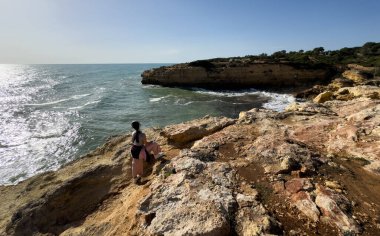 Kız okyanusun kenarında dinleniyor, denize bakıyor. Yüksek kalite fotoğraf