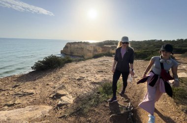 Uçurumun kenarındaki kadın yürüyüşçüler. Yaşam tarzı. Yürüyüş. Anne ve kızı güzel Algarve Praia da Morena 'da yürüyor. Yüksek kalite fotoğraf