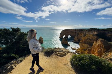 Portekiz, Algarve 'deki Marinha Sahili' nin tepesinden Atlantik Okyanusu 'nun tadını çıkaran bir kadın. Yüksek kalite fotoğraf