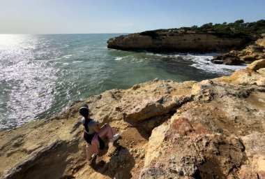 Güneşli ve açık bir bahar sabahında, gün doğumundan hemen sonra, Arnavutdeira sahilinin kayalıkları. Albandeira, Portekiz. Yüksek kalite fotoğraf