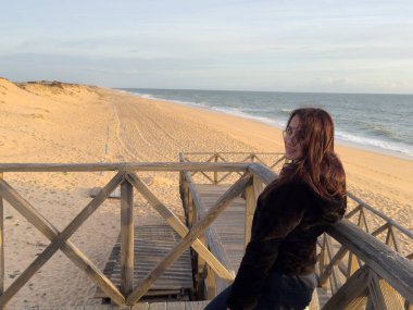 Kızıl kayalıkları ve kayalıkları olan güzel kumlu bir sahil. Günbatımında Atlantik kıyısında Algarve, Portekiz 'de sığ dalgalarla birlikte. Yüksek kalite fotoğraf