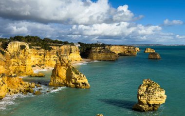 Altın kayalar, parçalı bulutlu bir gökyüzünün altında sakin mavi denizle buluşur. Malta 'nın güzel sahil şeridini gözler önüne serer. Yüksek kalite fotoğraf
