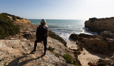 Kız okyanusun kenarında dinleniyor, denize bakıyor. Yüksek kalite fotoğraf
