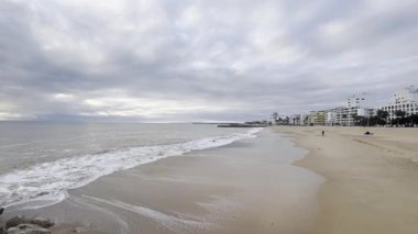 Atlantik 'te kumlu bir sahil. Kum taşı kayalıkları olan bir sahilin gün batımında manzara. Albufeira, Algarve, Portekiz yakınlarındaki Praia 'nın sarı sahilinde gelgit var. Yüksek kalite fotoğraf