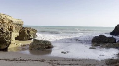 Güneşli ve açık bir bahar sabahında, gün doğumundan hemen sonra, Arnavutdeira sahilinin kayalıkları. Albandeira, Portekiz. Yüksek kalite fotoğraf