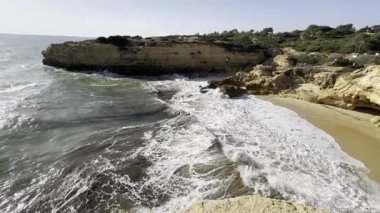 Güneşli ve açık bir bahar sabahında, gün doğumundan hemen sonra, Arnavutdeira sahilinin kayalıkları. Albandeira, Portekiz. Yüksek kalite fotoğraf