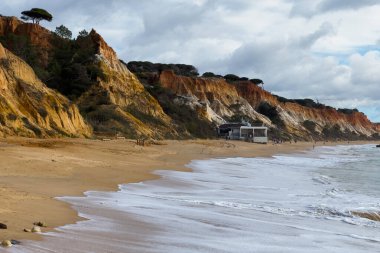 Güney Portekiz 'in Algarve bölgesinde yer alan Praia do Barranco das Belharucas plajının deniz manzarası ve kıyı şeridi. Praia do Barranco das Belharucas plajı, Albufeira, Algarve, Portekiz. Yüksek kalite fotoğraf