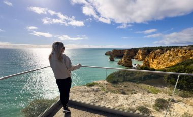Portekiz, Algarve 'deki Marinha Sahili' nin tepesinden Atlantik Okyanusu 'nun tadını çıkaran bir kadın. Yüksek kalite fotoğraf