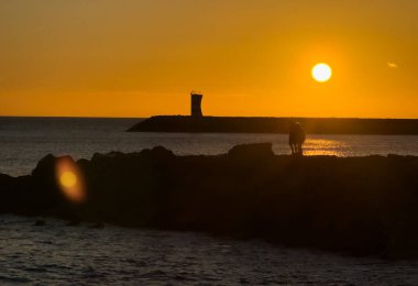 Marina de Vilamoura 'nın giriş kanalı üzerindeki kayalık deniz fenerinde Quarteira, Loule, Faro bölgesi, Algarve, Portekiz' deki Vilamoura Sahili 'nin yanındaki kırmızı ve beyaz deniz feneri. Yüksek kalite 4k görüntü