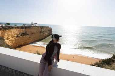 Kızım, kumsaldaki sarı kayalar ve kayalıklar. Deniz kenarında bir koy, Kaya Leydisi, Praia Nova, Lagos. Algarve, Portekiz. Yüksek kalite fotoğraf