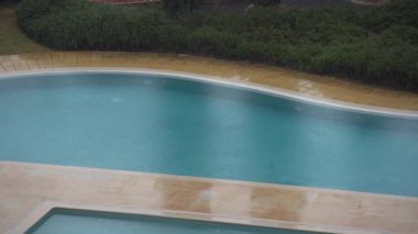 Güverte sandalyeli yüzme havuzunun yanındaki dinlenme odasının penceresinden bak. Muhteşem arka bahçenin iç tasarımı ve dinlenmek için geniş bir avlu. Yüksek kalite 4k görüntü