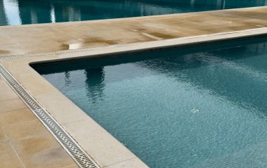 Havuzun beyaz taş kenarı ve mavi havuz suyu dokusu. Üst görünüm, kopyalama alanı, tasarım şablonu. Yüksek kalite fotoğraf