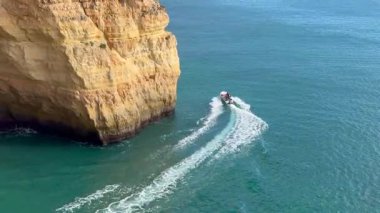 Berrak mavi deniz ve altın kayalıklarıyla göz kamaştırıcı körfezi ziyaret eden botlar Portekiz kıyısı Lagos Portugal. Yüksek kalite fotoğraf