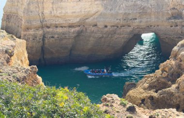 Berrak mavi deniz ve altın kayalıklarıyla göz kamaştırıcı körfezi ziyaret eden botlar Portekiz kıyısı Lagos Portugal. Yüksek kalite fotoğraf