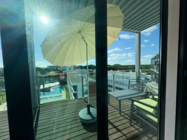 Güneşli yaz gününde ahşap paletler, şemsiyeler ve süslemelerle dolu rahat bir çatı terası. Yüksek kalite fotoğraf