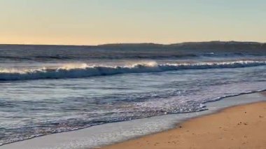 Okyanus ufkunda altın gün batımı sakin, doğal deniz manzarası ve açık gökyüzünü gösteriyor. Yüksek kalite fotoğraf