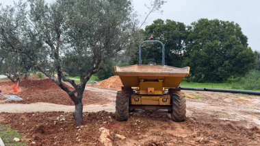 Ağır makineler inşaat sahasına toprak taşırken zemin seviyelendirme ve inşaat hazırlıklarına net bir şekilde odaklanıyorlar. - Evet. Yüksek kalite fotoğraf