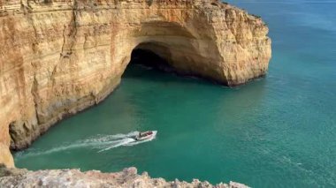 Berrak mavi deniz ve altın kayalıklarıyla göz kamaştırıcı körfezi ziyaret eden botlar Portekiz kıyısı Lagos Portugal. Yüksek kalite fotoğraf