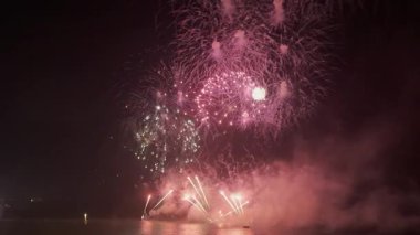 Gece gökyüzünde havai fişek gösterisi kutlamalarında büyük, güzel, renkli bir havai fişek gösterisi. Yüksek kalite 4k görüntü