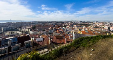 Portekiz 'in Lisboa kentindeki geleneksel çatıların manzarası, terracotta fayansları ve tarihi mimarisi, canlı bir kentsel manzara yaratıyor, yatay. Yüksek kalite fotoğraf