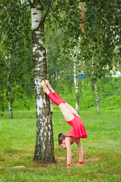 Ung vacker preteen flicka gör gymnastik utomhus — Stockfoto