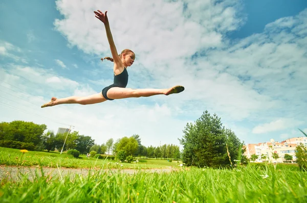 Young beautiful preteen girl doing gymnastics outdoors — Stock Photo, Image